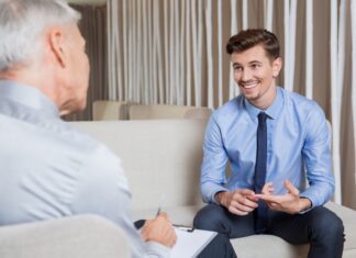 A smiling businessman in a blue suit and shirt receives advice from an ethical debt collector