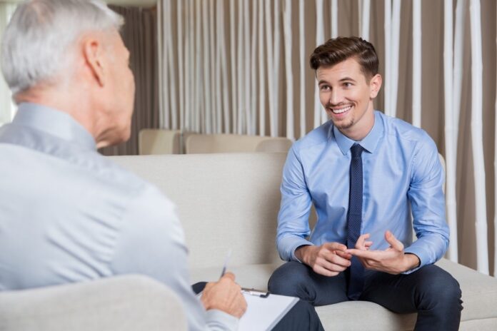 A smiling businessman in a blue suit and shirt receives advice from an ethical debt collector