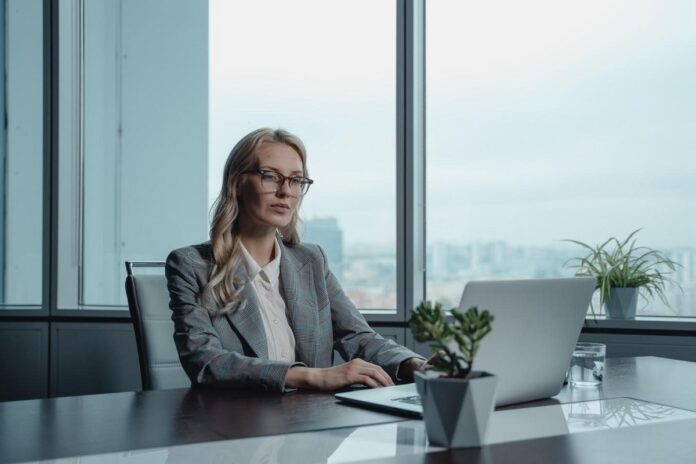 Sharply dressed real estate investor using her laptop to explore business opportunities Sharply dressed real estate investor using her laptop to explore business opportunities
